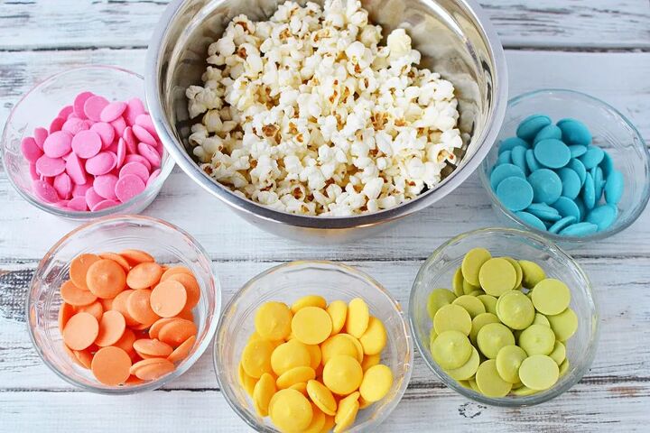 rainbow popcorn snack or party mix, A bowl of popcorn and a rainbow of colors of candy melts in bowls