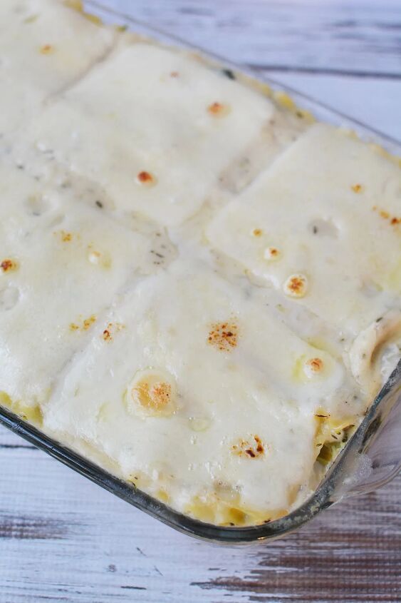 creamy chicken and spinach lasagna recipe, Cheese on top of lasagna in a baking dish
