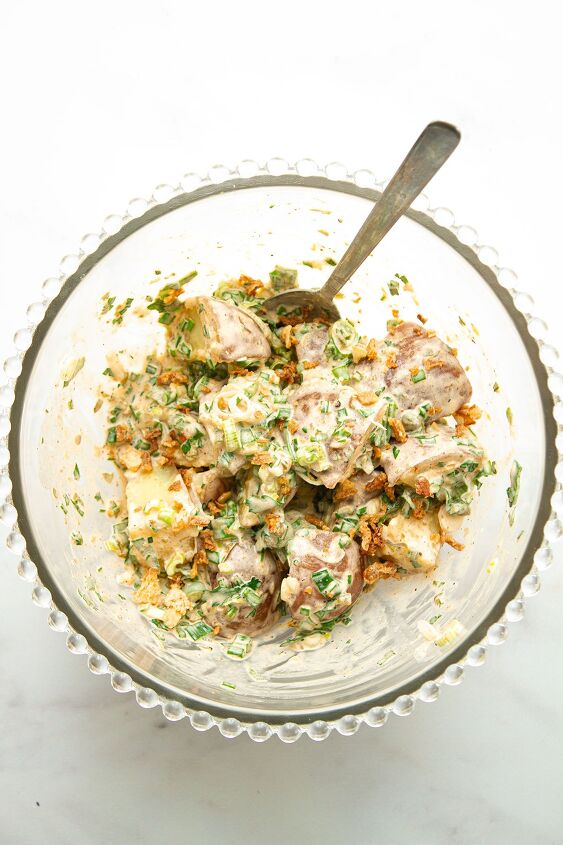 the best easy creamy red skin potato salad no egg, The cooked potatoes tossed in a glass bowl with the dressing