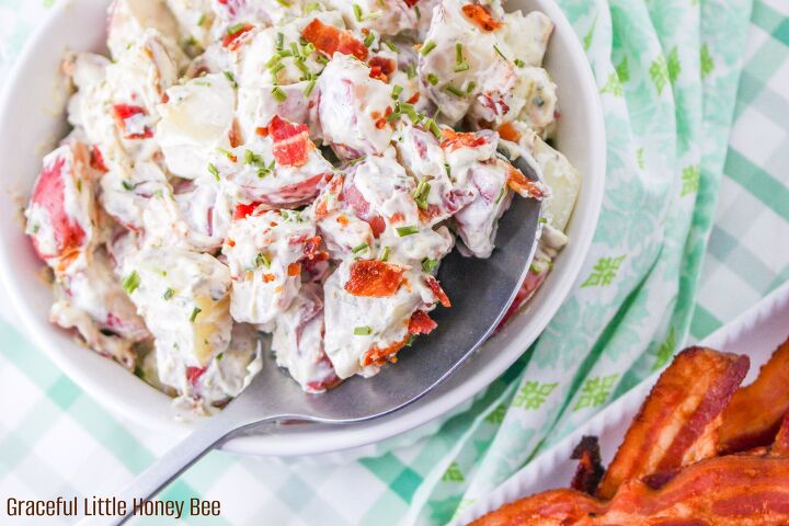bacon ranch potato salad, Aerial view of potato salad in a white bowl with a spoon resting in it