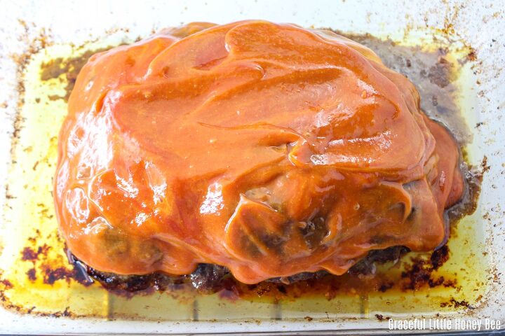 old fashioned meatloaf recipe with crackers, Cooked meatloaf covered in ketchup and mustard mixture in a glass baking dish