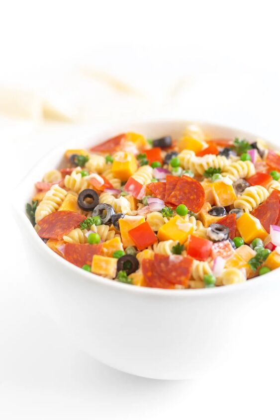 the throwback creamy pasta salad everyone will rave about, bowl of pasta salad with spiral pasta pepperoni black olives onions