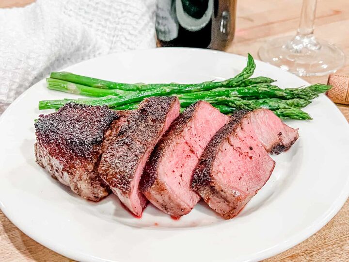 the best wine with filet mignon steak pairing guide, Filet mignon sliced on a plate with asparagus and a filet mignon wine pairing