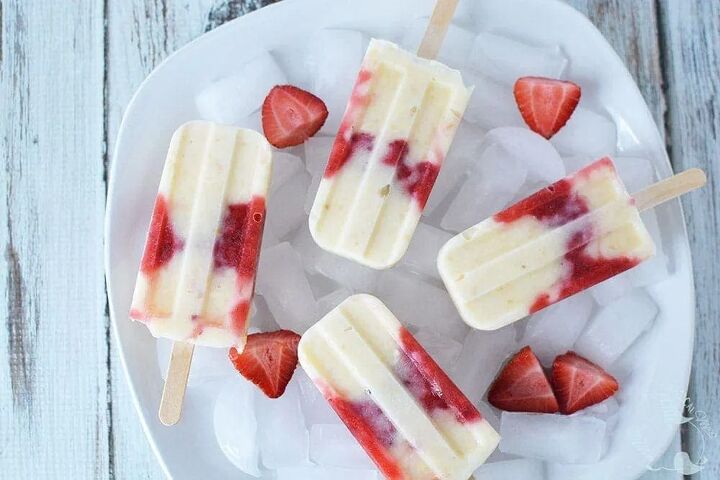 creamy and delicious cheesecake popsicle recipe, Strawberry cheesecake pops in a bowl with ice and strawberries