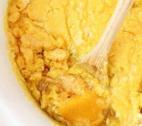 slow cooker peach cobbler, Peach cobbler in a white slow cook and wooden spoon