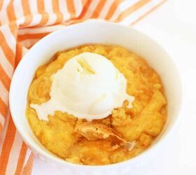slow cooker peach cobbler, A white bowl of peach cobbler with vanilla ice cream and an orange striped napkin
