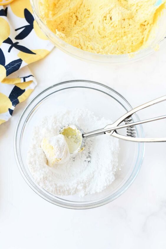 lemon cookies made with cool whip a perfect summer treat, A cookie scoop with dough in powdered sugar