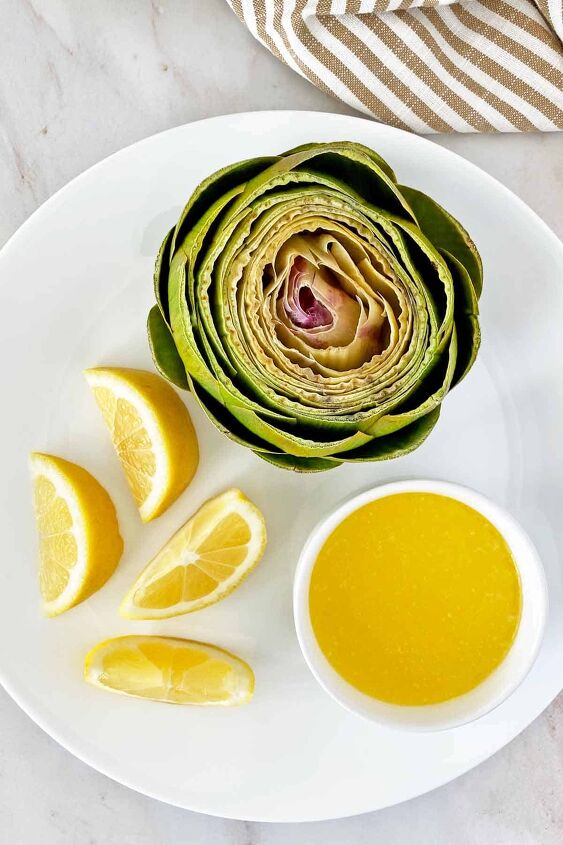how to microwave an artichoke, A microwave steamed artichoke on a serving plate with lemon slices and melted butter