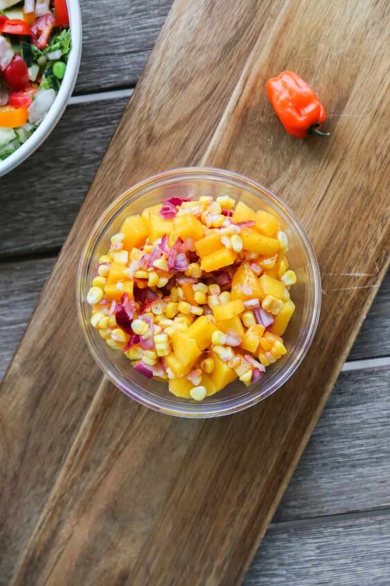mango corn salsa, mango corn salsa in a glass bowl on a cutting board