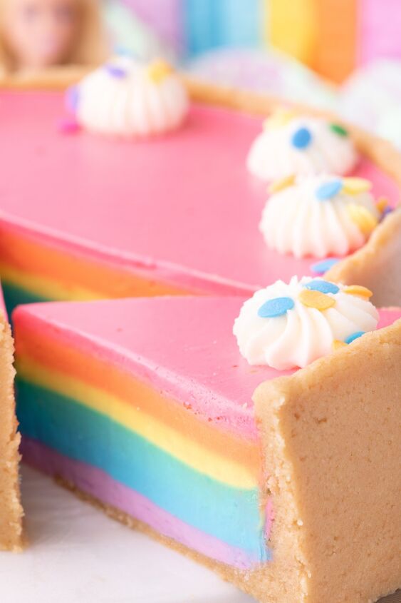 how to make a show stopping barbie no bake rainbow cheesecake, gorgeous slice coming out of a rainbow cheesecake