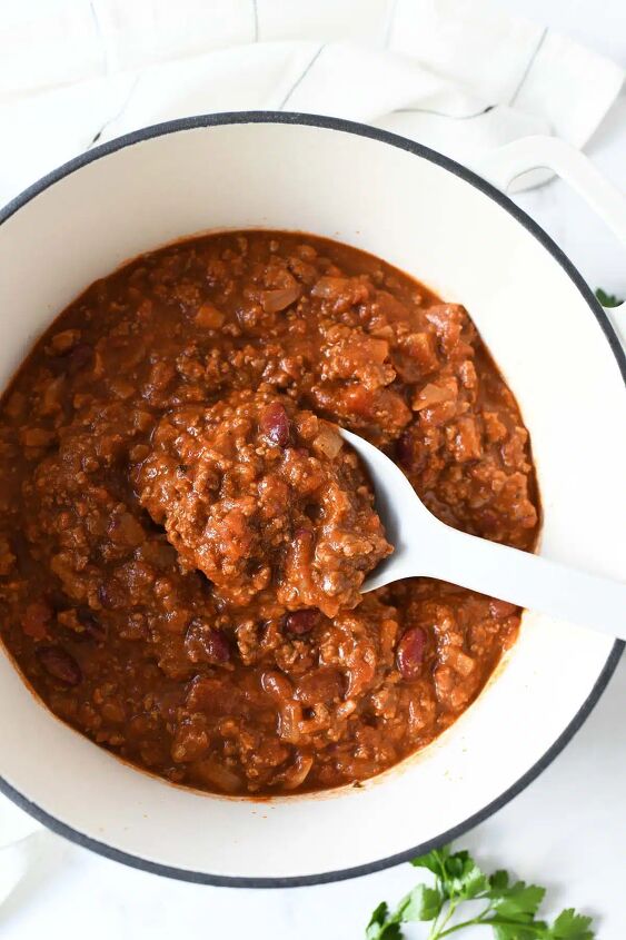 quick and easy classic chili recipe, Meaty chili in a white Dutch oven with a white spoon