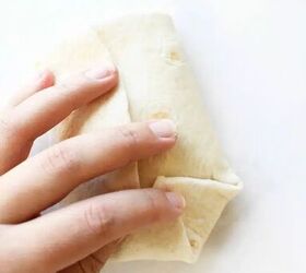 how to make beef chimichanga quick and easy, A hand holding a folded chimichanga before baking