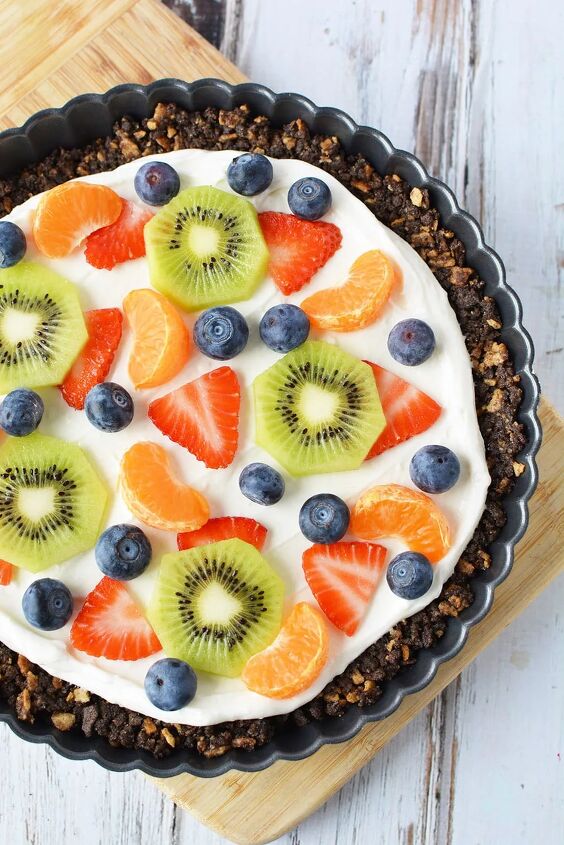 fresh fruit pizza dessert with ice cream cone crust, A tart pan with sugar cone crust topped with cream cheese frosting and fresh fruit