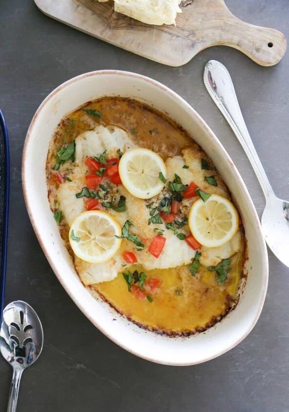 baked greek cod recipe gluten free, baked greek cod in a dish garnished with lemons and tomatoes