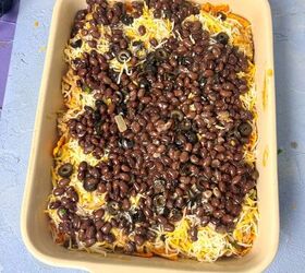 dorito casserole with ground beef, black beans on cheese and beef layers in a casserole dish