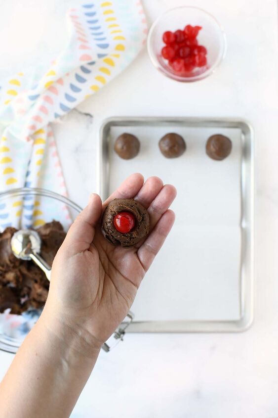 chocolate covered cherry brownie truffles, A white hand holding a cherry brownie truffles inside of it