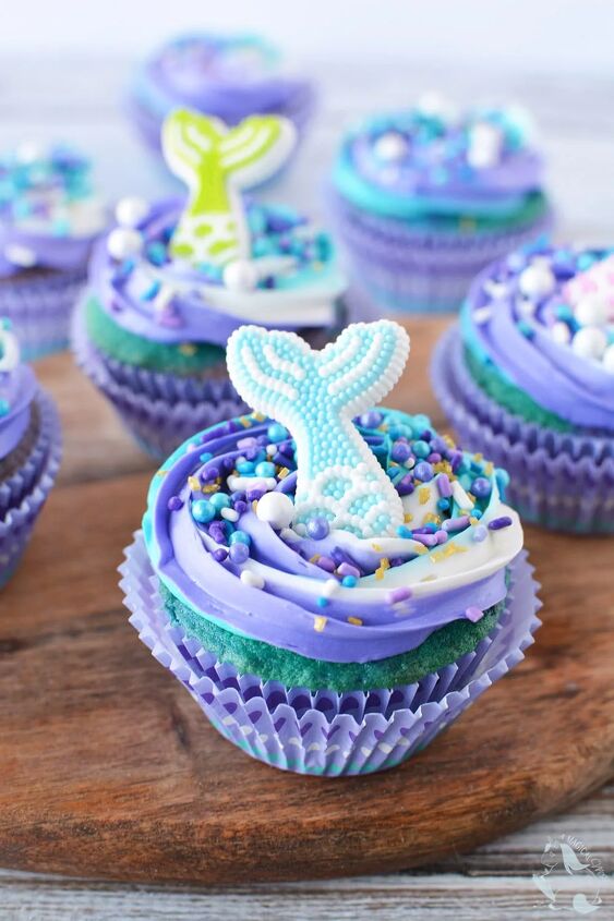 swirly blue and purple mermaid cupcakes, Mermaid cupcake sitting on a board with more cupcakes in the background