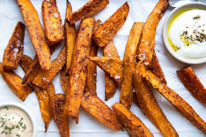 air fryer sweet potato wedges, air fryer sweet potato wedges on a white piece of parchment paper sprinkled with parmesan cheese and salt