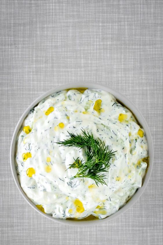tzatziki, A bowl filled with tzatziki garnished with dill viewed from above The gray table top from the 1950s can be seen in the background