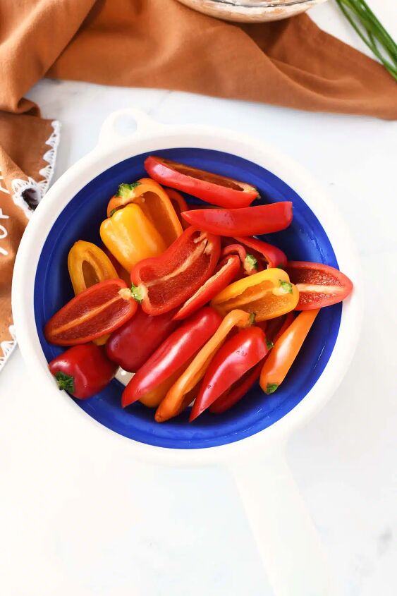 baked buffalo chicken sweet pepper bites, Halved mini rainbow peppers in a blue and white colander