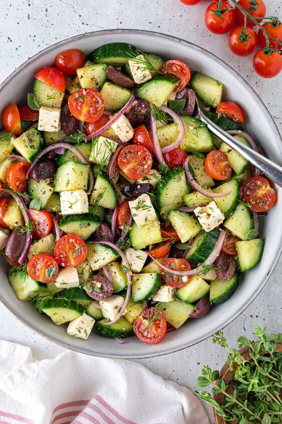 easy greek cucumber salad with feta, A bowl of Greek cucumber salad with a spoon