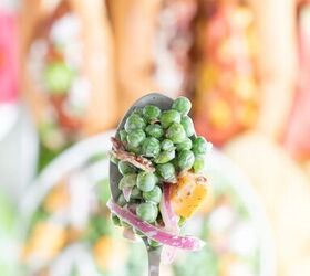 how to make classic pea salad, up close view of spoonful of classic summer pea salad with cheese chunk slivered onions and bacon bits