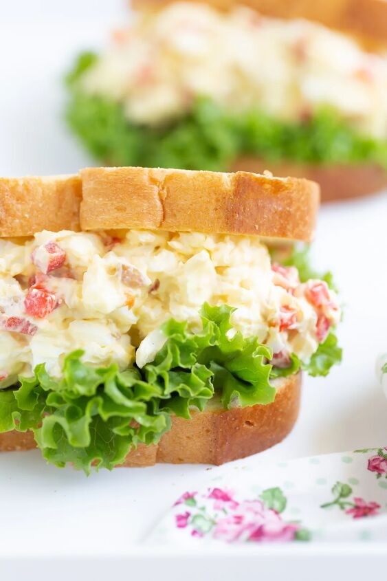 my great grandma s interesting radio egg salad recipe, tall stuffed egg salad sandwich with pimientos on a bed of lettuce and white sliced bread