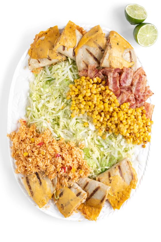 this family style quesadilla salad is better than restaurant versions, family sized salad being put together on a large tray with shredded lettuce rice corn bacon