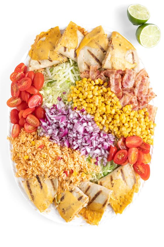 this family style quesadilla salad is better than restaurant versions, over top photo of a salad being made with shredded lettuce grape tomatoes mexican rice bacon quesadillas