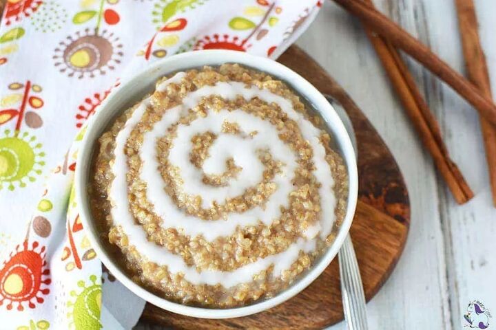 filling and delicious cinnamon roll oatmeal recipe, Bowl of oatmeal with a cinnamon roll swirl next to cinnamon sticks