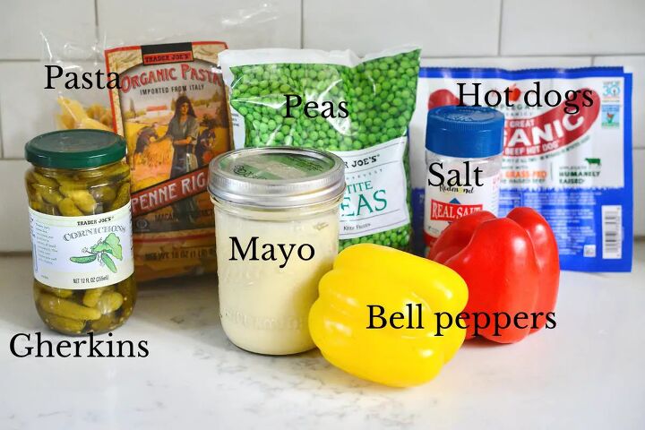 classic creamy german pasta salad nudelsalat, jar of gherkins package of dried pasta frozen peas jar of mayonnaise hot dogs yellow and red bell pepper salt