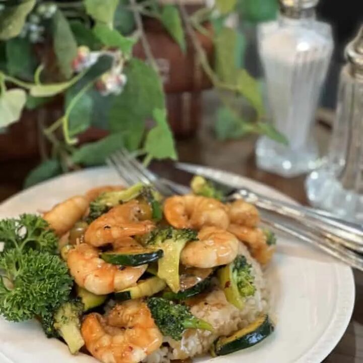 how to make delicious honey garlic butter shrimp and zucchini, salt and pepper shaker green ivy plant white plate with bead detail fork and knife brown rice