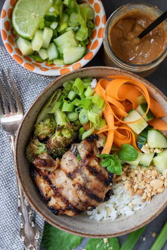thai chicken rice bowls with peanut sauce, A Thai rice bowl with grilled chicken There s crushed peanuts cucumber carrots mint and broccoli on top of the bowl