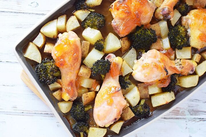 peach chicken sheet pan dinner recipe, A sheet pan filled with chicken legs broccoli and potatoes covered with a peach topping