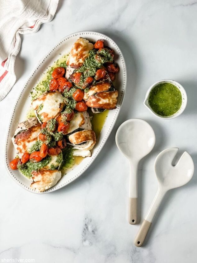 easy one pan basil halloumi chicken, basil halloumi chicken on a ceramic platter with ceramic serving utensils