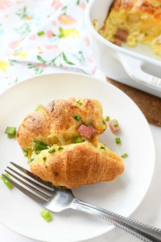 ham cheese crescent roll breakfast casserole, A bubbly slice of crescent roll casserole on a white plate