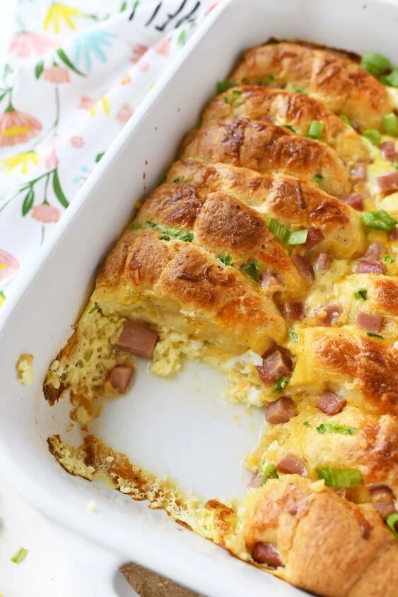 ham cheese crescent roll breakfast casserole, A slice of casserole missing from a white dish