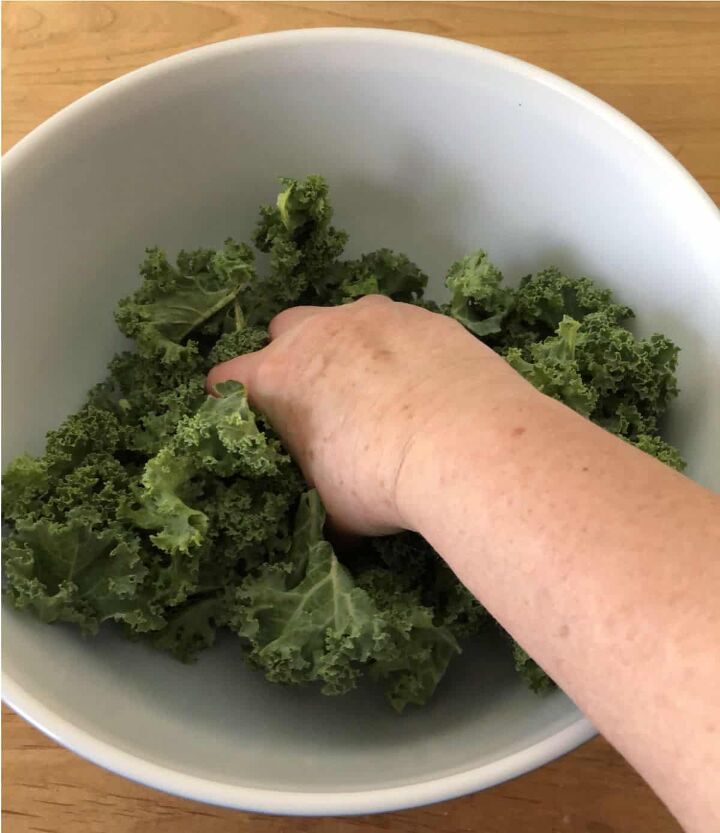 massaged kale, squeezing kale leaves in a bowl