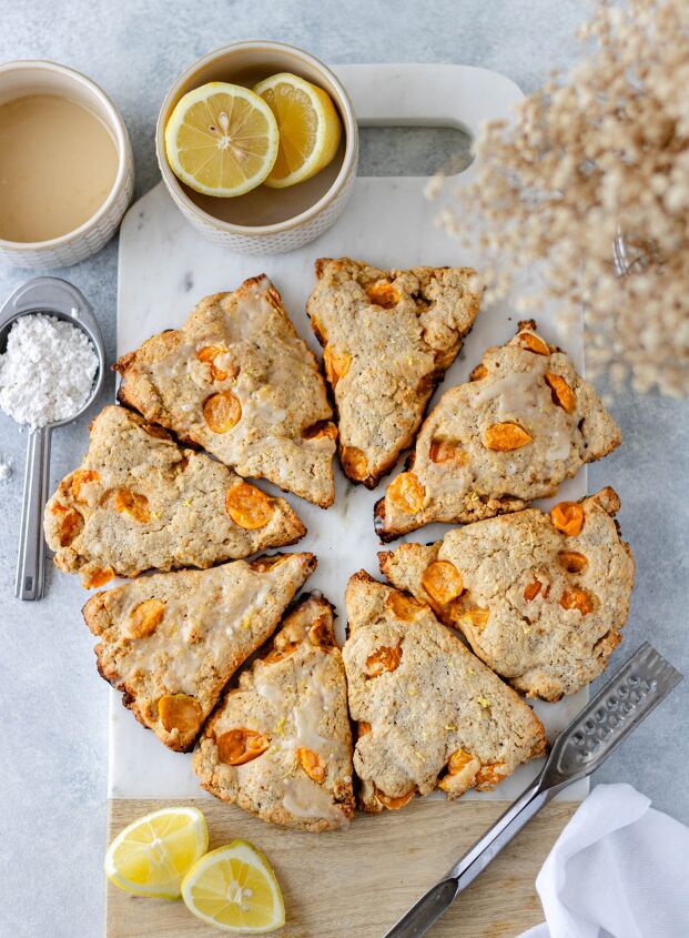 cape gooseberry scones with lemon, Eight Cape Gooseberry Scones with Lemon arranged in a circle resting on a marble cutting board and surrounded by baby s breath lemon wedges and a white tea towel