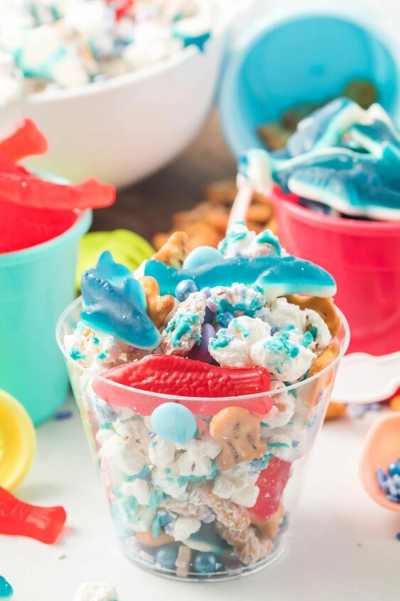 how to make shark bait snack mix, clear cups filled with shark bait snack mix with gummy sharks and swedish fishes