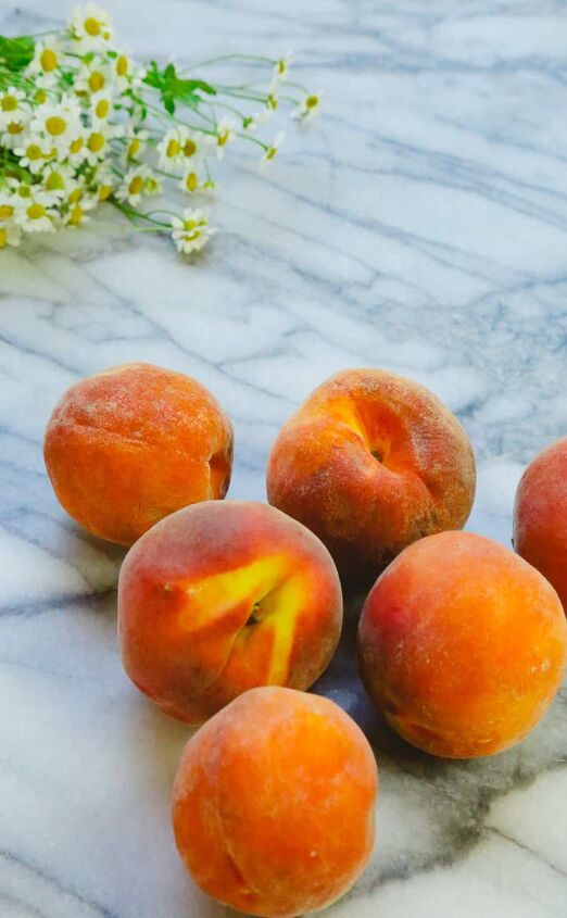 honey peach pie homemade, peaches on a marble backdrop with chamomile flowers