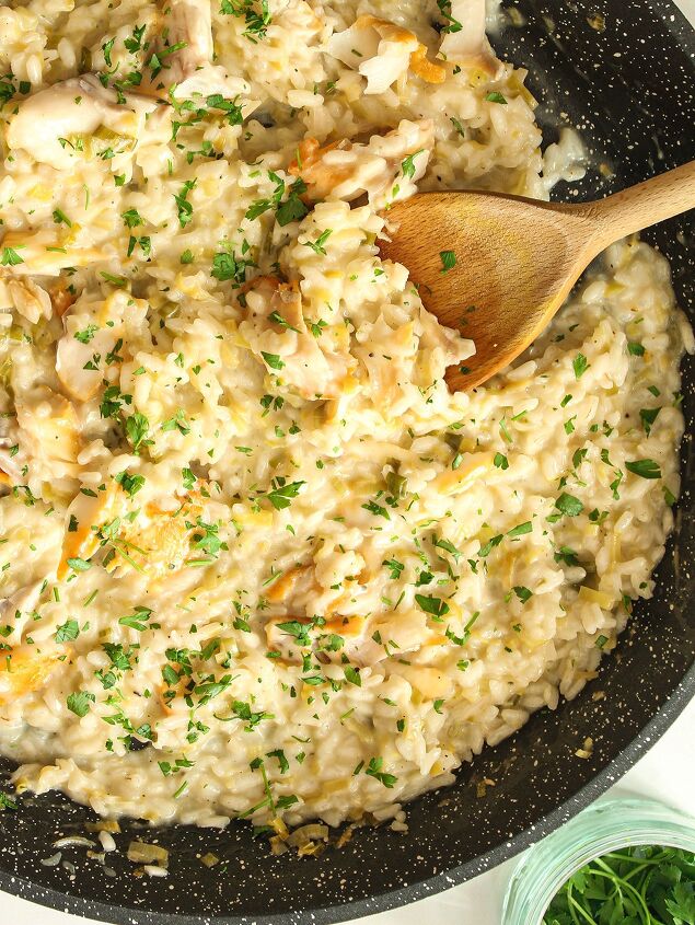 smoked haddock and leek risotto easy one pan recipe, Creme fraiche added to the saut d leeks and spring onion scallions and rice stirred with a wooden spoon in a dark coloured pan
