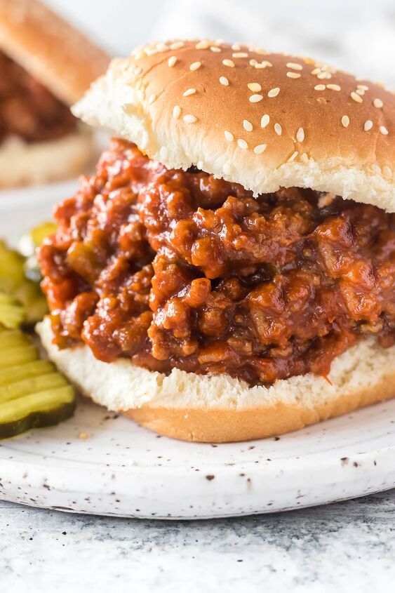 how to make classic sloppy joes with ketchup, up close view of a huge sloppy joe on a sesame seed hamburger bun