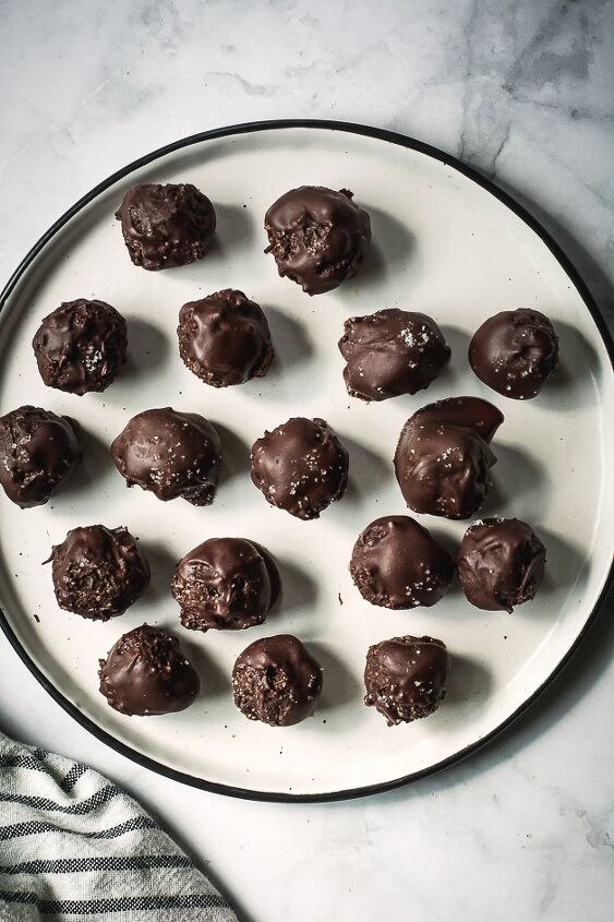 no bake brownie bites with adaptogenic mushroom powder vegan paleo, chocolate balls on a white plate on a tabletop from above