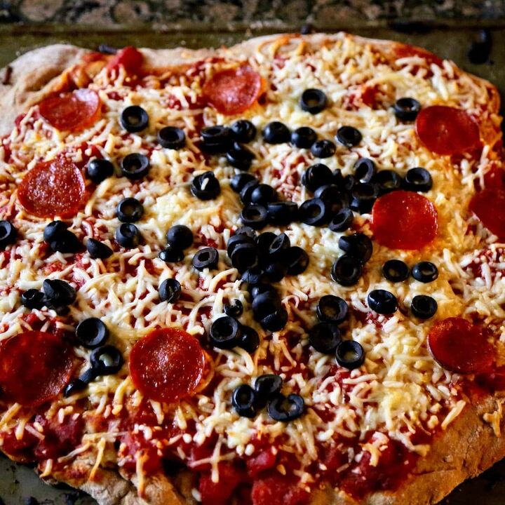 fresh pizza dough with whole wheat flour, pepperoni pizza with olives close up