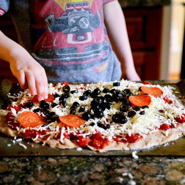 fresh pizza dough with whole wheat flour, adding pepperoni to pizza
