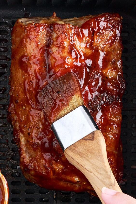 the 20 minute air fryer ribs you ll be craving, using a food brush to slather on bbq sauce onto air fried ribs
