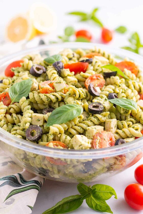 vegan pesto pasta salad, Vegan pesto pasta salad in a glass mixing bowl with basil tomatoes and lemon in background