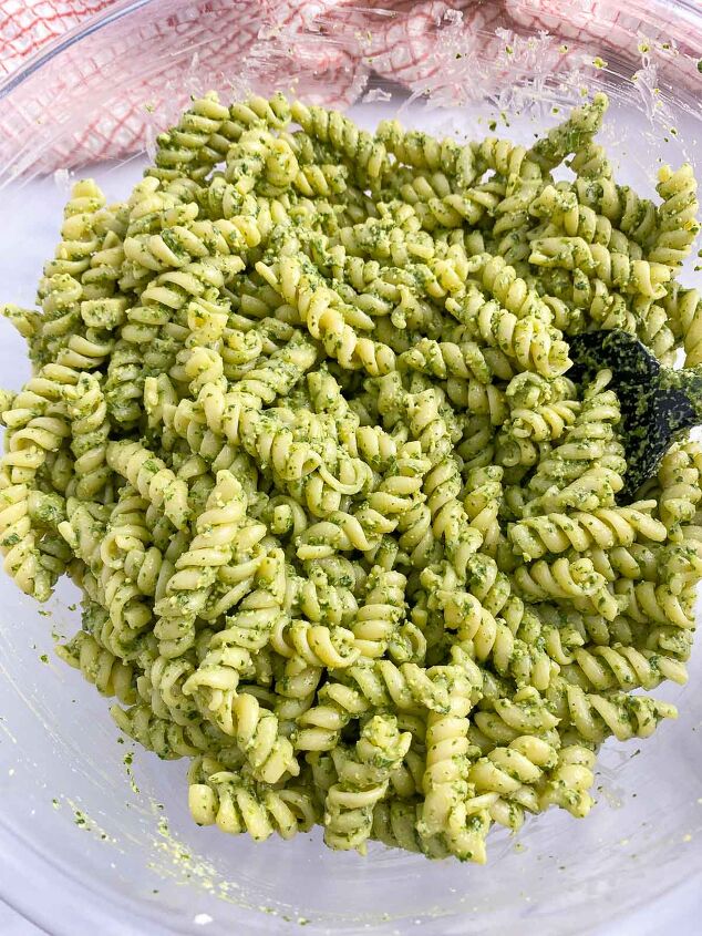 vegan pesto pasta salad, Pesto mixed into pasta in large mixing bowl