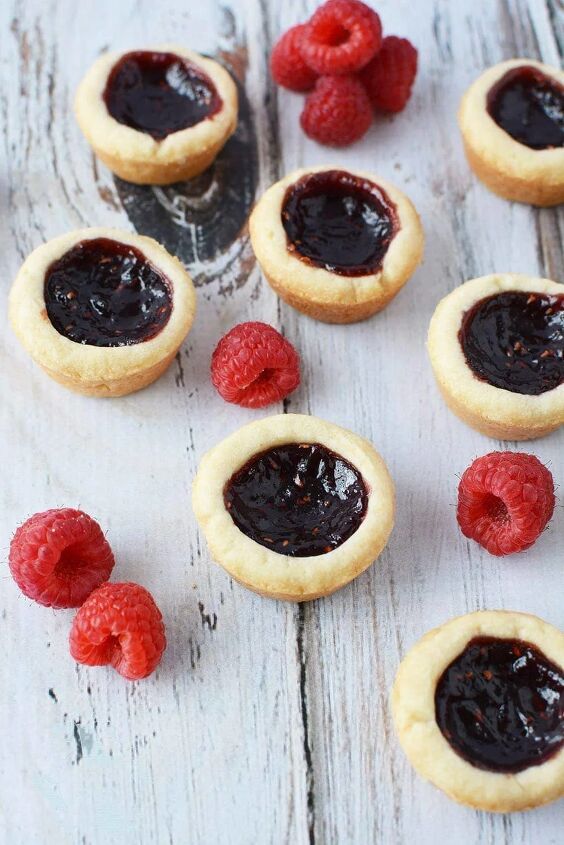 easy raspberry tarts recipe bite sized buttery crunch, Mini raspberry tarts on a table with fresh raspberries